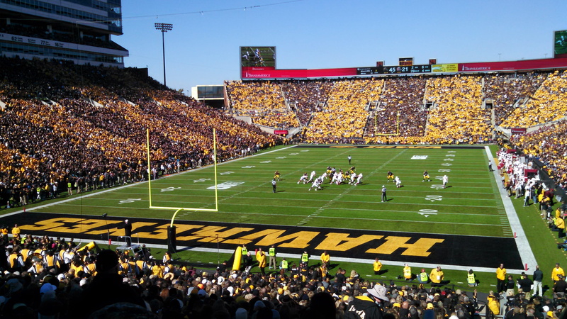 green, day, large group of people, playing, high angle view, iowa, built structure, iowa city, football field, leisure activity, match - sport, watching
