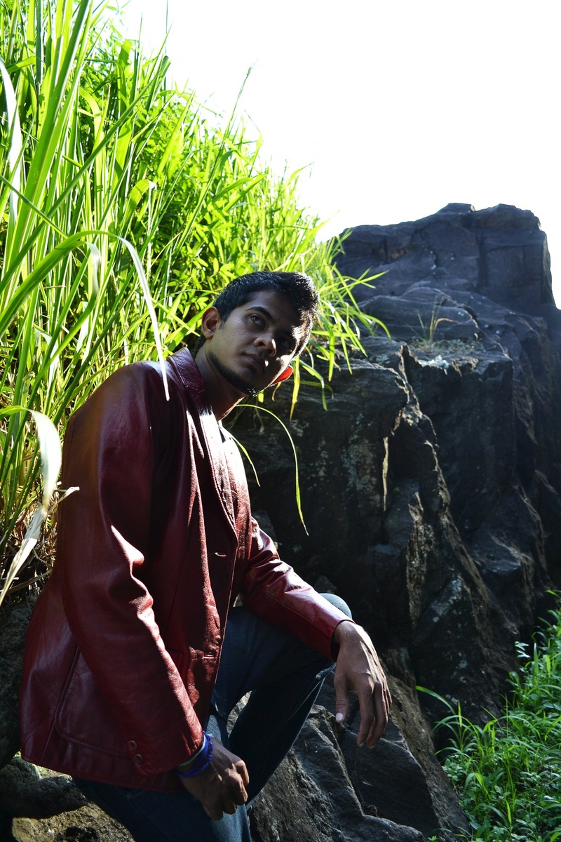fashion, one person, young adult, three quarter length, real people, sitting, rock, boy, ceylon, pose, t-shirt, jacket, mawanella, plant, green color, leisure activity