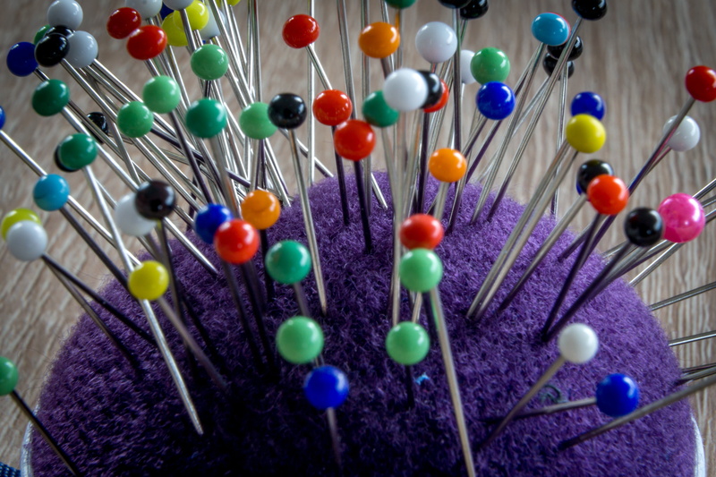 sewing item, abundance, selective focus, sew, sphere, variation, close-up, pin, high angle view, macro, decoration, purple, lot, indoors, wood - material