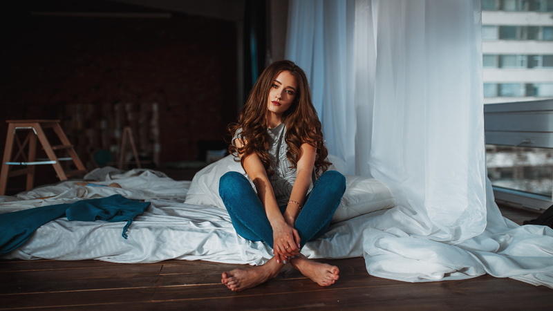 beautiful woman, legs crossed, one person, indoors, lifestyles, grey shirt, home interior, young adult, bedroom, sitting, brunette, long hair, hairstyle