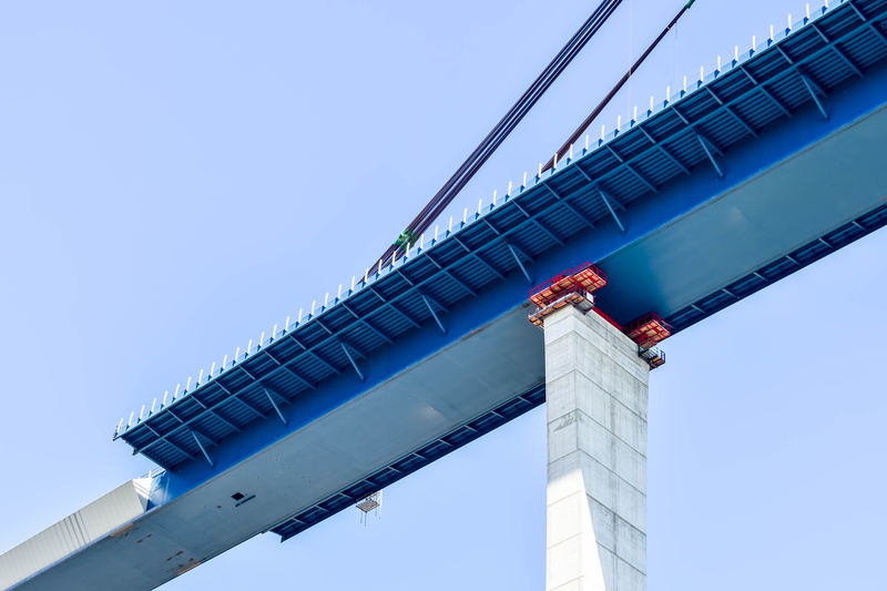 clear sky, concrete, no people, built structure, bridge, steel, construction, blue, copy space, cables, red, pillar, gray, outdoors, sky, unfinished, nature