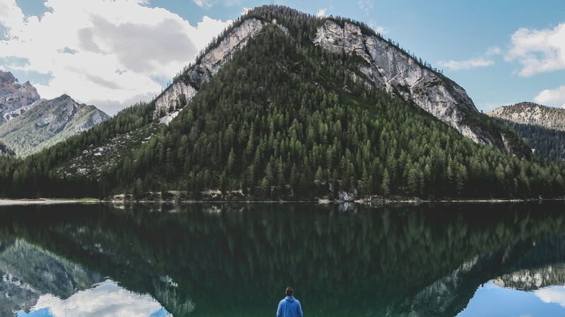cloud, tree, reflection, mountain range, outdoors, pragser wildsee, non-urban scene, forest, blue, idyllic, beauty in nature, outside, one person, nature