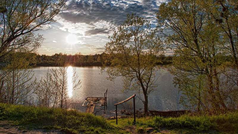 sunbeam, outdoor play equipment, lake, beauty in nature, cloud - sky, scenics - nature, plant, no people, grass, absence, change, sun, outdoors, day, tranquility
