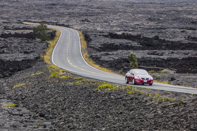 highway, land vehicle, transportation, sign, red, rock - object, nature, volcanic, sedan, curve, travel, mountain, high angle view, top, stones, mode of transportation