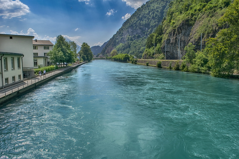 outdoors, architecture, tranquil scene, no people, interlaken, built structure, cloud - sky, sky, flowing water, waterfront, day, mountain, turquoise colored