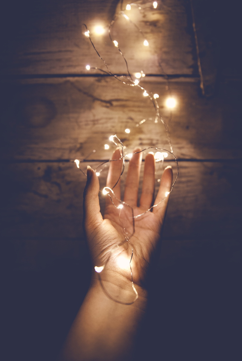 personal perspective, lighting equipment, illuminated, fairy light, surface, real people, light, night, women, human body part, glowing, holding, near