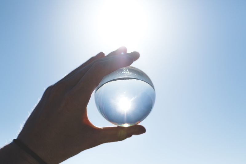 outdoors, body part, clear, sunlight, fortune telling, holding, ball, one person, finger, crystal ball, transparent, sun glare, human limb, glass - material