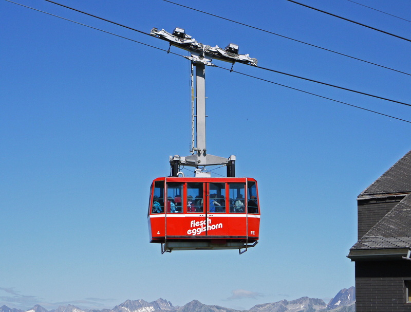 low angle view, no people, blue, 2K, day, mode of transportation, overhead cable car, arrival central station, snow, eggishorn, mountain peaks, built structure