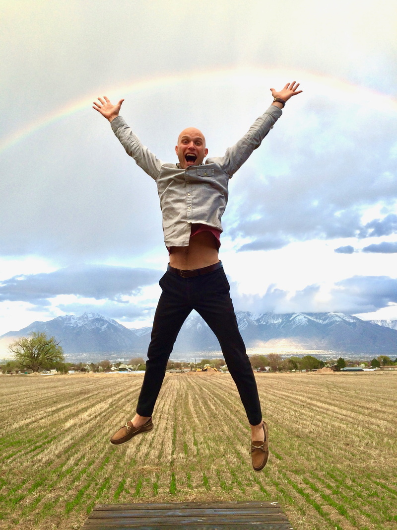 expression, real people, outdoors, excitement, excited, lifestyles, freedom, standing, field, land, limb, rainbow, jumping, arms raised, sky, man smiling
