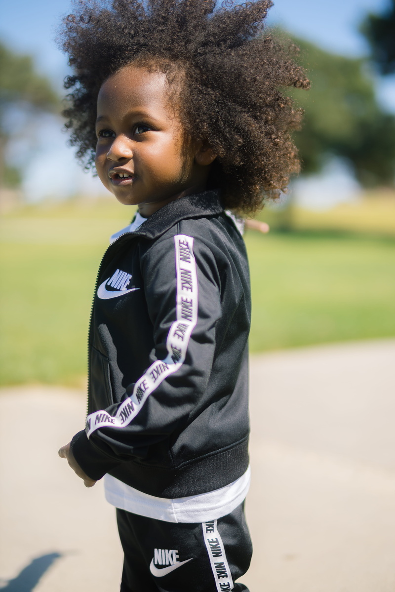 person, photography, child, clothing, innocence, real people, nike, female, fashion, grass, lifestyle, kids fashion, brand, one person, outdoors, 5K, childhood