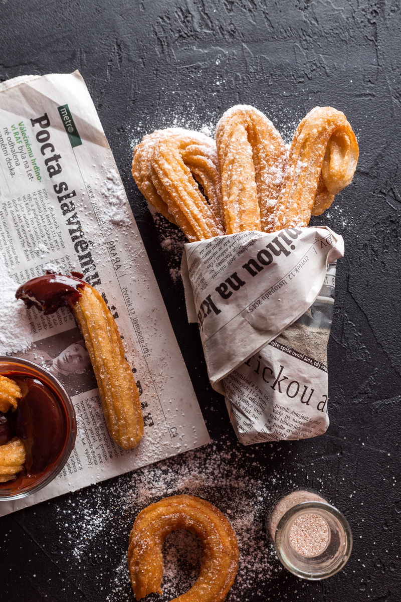 studio shot, snack, sweet food, churos, food and drink, dip, delicious, high angle view, close-up, paper, flour, baked pastry item, text, freshness, bread