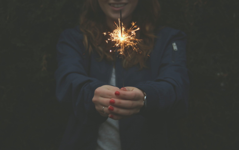 blue jacket, leisure activity, front view, sparkle, event, sparks, illuminated, sparkler, person, glowing, flame, fire - Natural Phenomenon, woman, blue