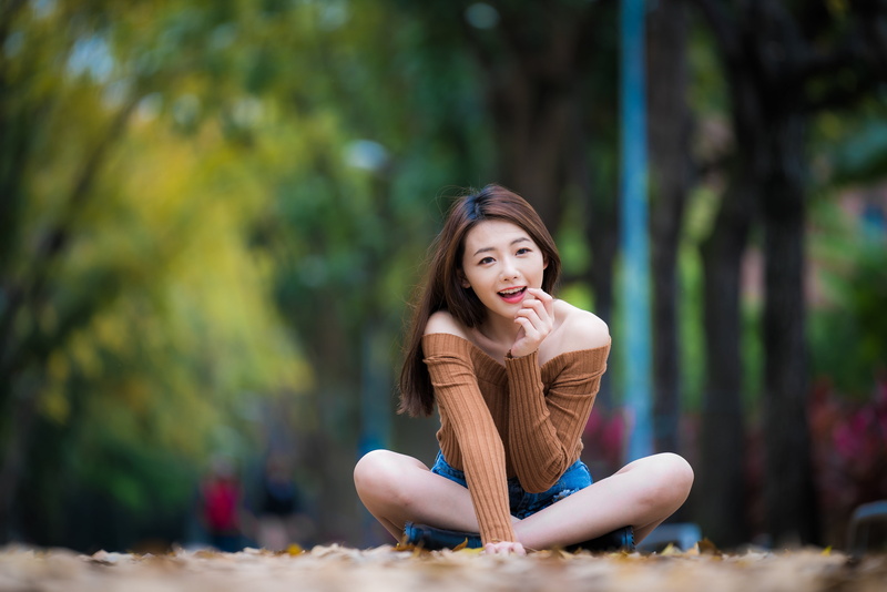 jean shorts, women, street, 4K, Asian, model, smiling, long hair, women outdoors, legs crossed, sweater, sitting, portrait, pink lipstick, brunette, looking away