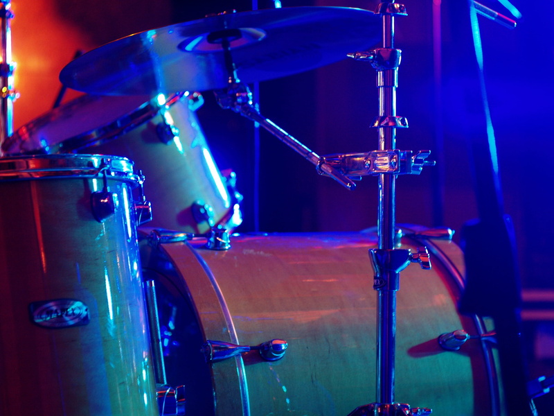 drum kit, illuminated, focus, nightlife, brown, concert, light, beat, shiny, cymbal, metal, photography, event, stage - performance space, percussion instrument