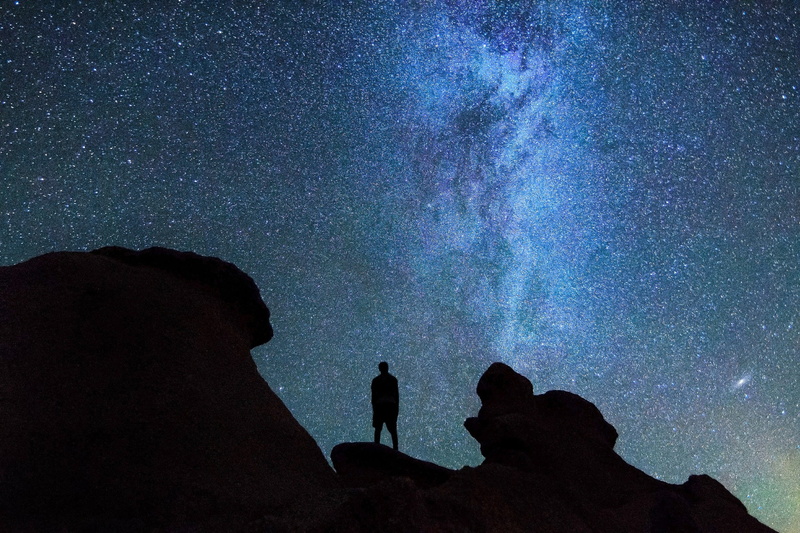 beauty in nature, men, solid, starry, man, space and astronomy, rock, nature, rock formation, sky, scenics - nature, galaxy, silhouette, outdoors, real people