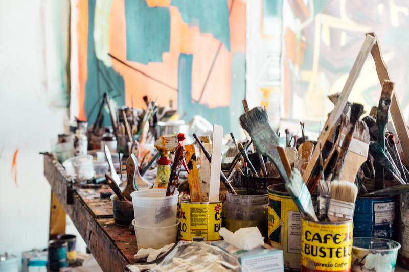 no people, easel, creativity, brush, workshop, light, studio, large group of objects, paint, paint brush, 5K, clutter, paintbrush, assorted, focus on foreground