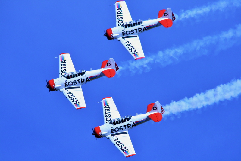 air show, outdoors, network connection plug, no people, nature, airplane, text, 4K, red, transportation, direction, sign, sunny, colored background, stunt