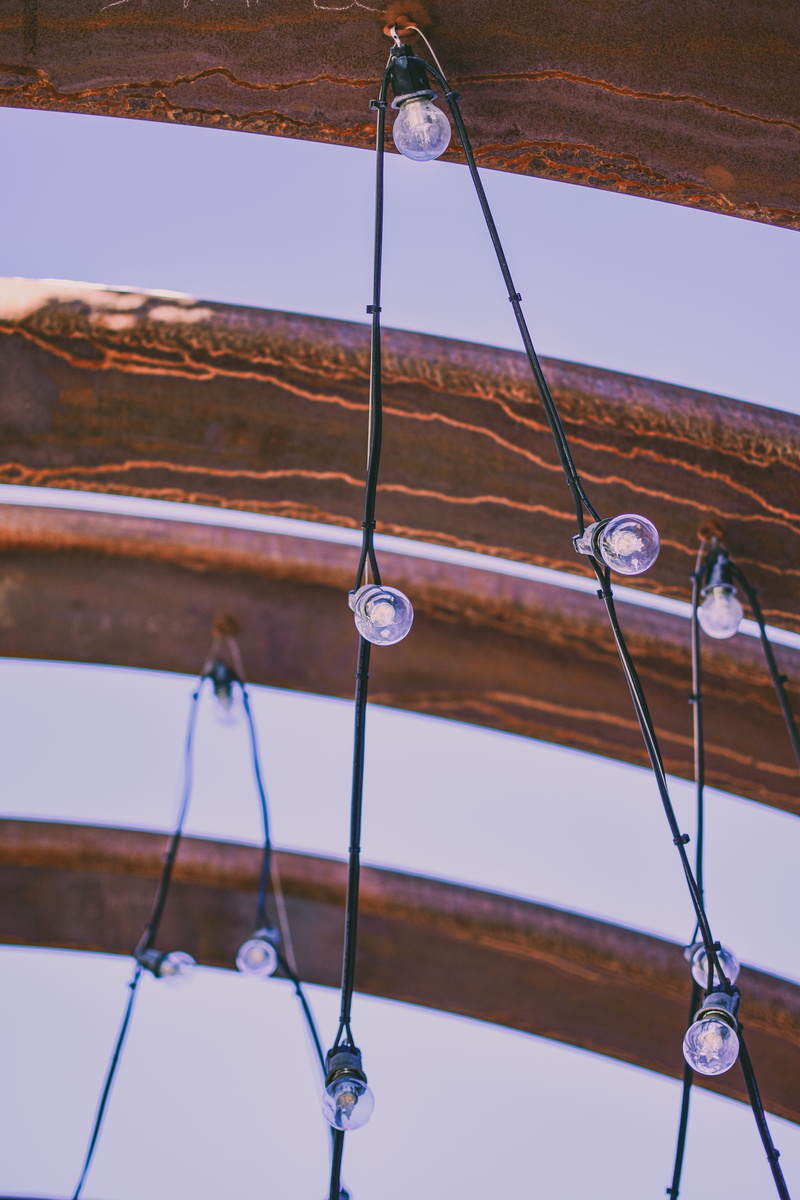 built structure, cable, wood - material, low angle view, light bulbs, architecture, ceiling, sky, day, hanging, outdoors, clear sky, decoration, close-up