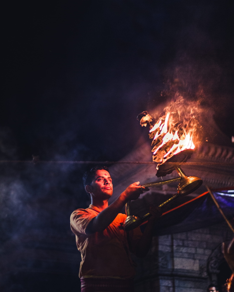 burning, nature, flames, lakes, fire - natural phenomenon, hindu, religion, lights, real people, heritage, sign, god, eyes, occupation, performance, waist up