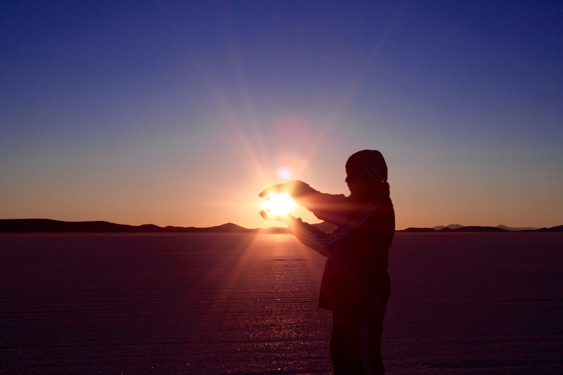 lens flare, sky, real people, bright, orange color, tranquil scene, silhouette, bolivia, sunbeam, leisure activity, lifestyles, salt flats, beauty in nature