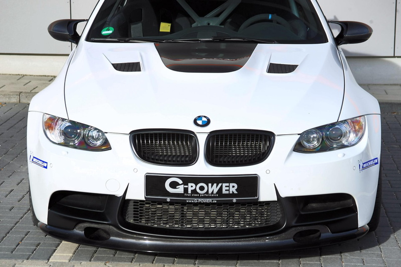 front view, day, m, close-up, white color, western script, land vehicle, gts, stationary, luxury, headlight, metal, motor vehicle, ii, wealth, group of objects