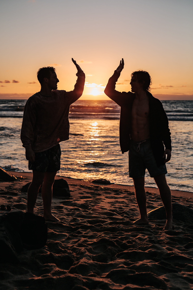 standing, lifestyle, friend, beauty in nature, leisure activity, seaside, sky, sand, mens, highfive, evening, land, togetherness, silhouette, near, sunset