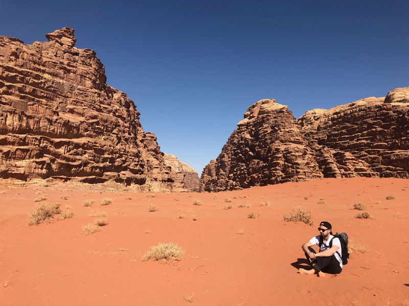 backpack, solid, hot, sky, dry, non-urban scene, man, adult, daylight, land, black, soil, grass, clear sky, nature, sunglasses, shirt, climate, travel destinations