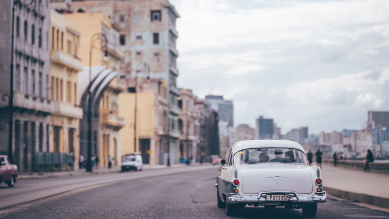 transportation system, town, blurred background, building exterior, outdoors, daylight, car, transportation, urban, mode of transportation, focus on foreground