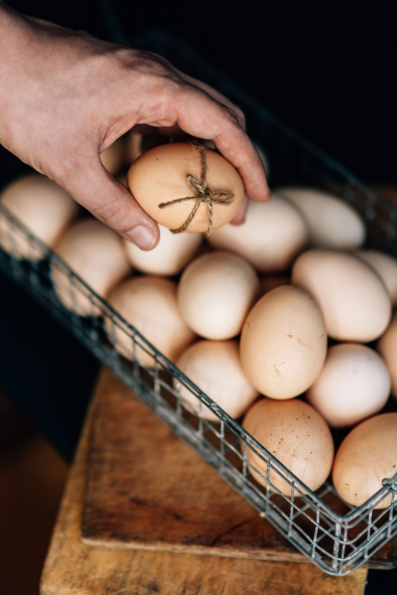 egg, selective focus, freshness, high angle view, human body part, indoors, large group of objects, breakfast, holding, focus on foreground, brown, raw Food