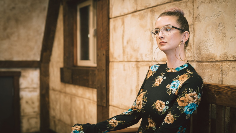 wall, glasses, lifestyles, face, woman, contemplation, portrait, bench, hair, looking away, top, model, floral pattern, hairstyle, fashion, adult, floral