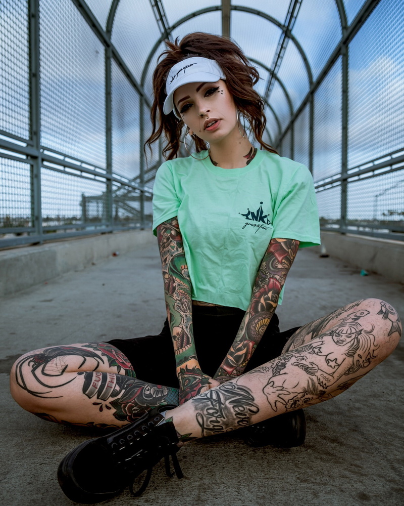 open mouth, skinny, high waisted, shorts, eyelashes, model, bridge, green top, black shorts, sky, makeup, natural light, baseball cap, earring, brunette