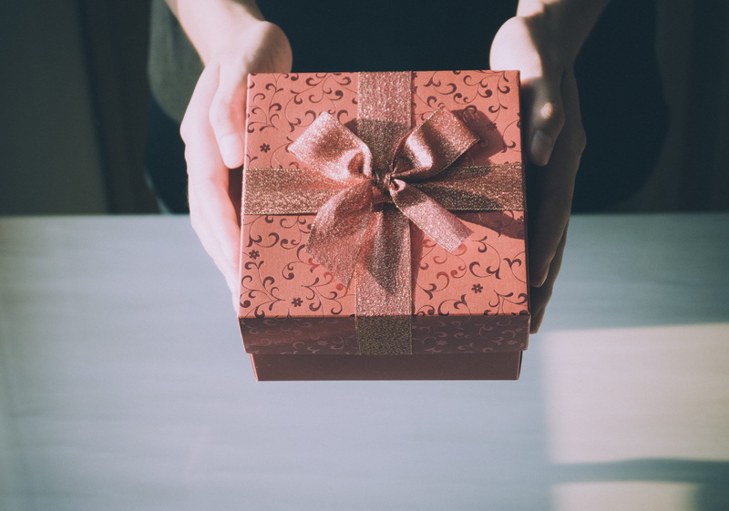 generosity, hands, hand, wrapped, holding, wrapping paper, box - container, human hand, one person, ribbon - sewing item, gift box, indoors, container