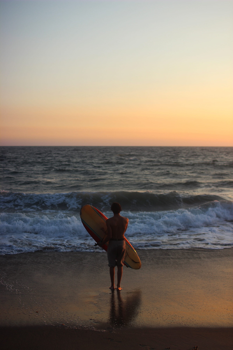 sea, lifestyles, land, carrying, nature, one person, beauty in nature, real people, scenics - nature, holding, beach, daytime, surf, leisure activity, standing