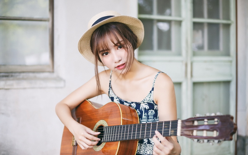 plucking an instrument, real people, women, casual clothing, musical equipment, one person, front view, leisure activity, music, arts culture and entertainment