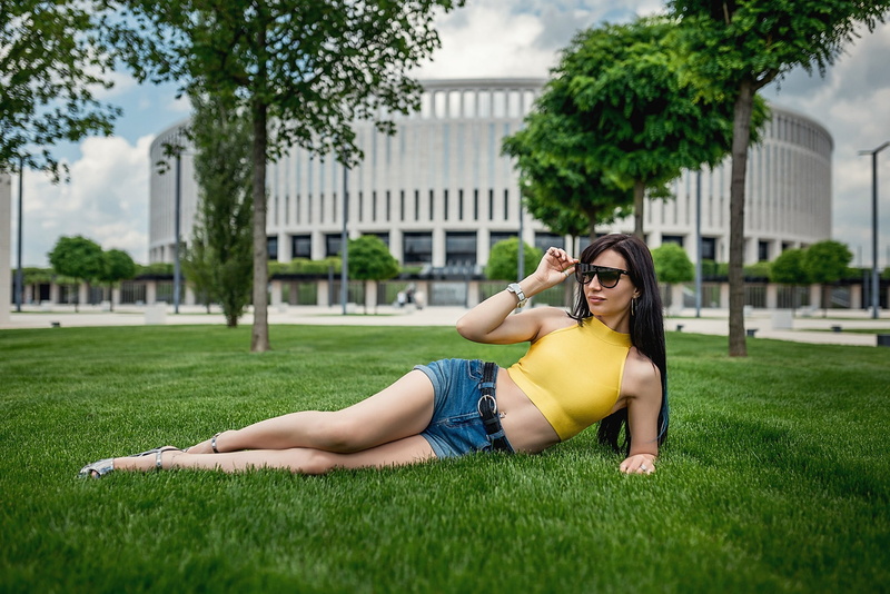 jean shorts, glasses, 1080P, full length, casual clothing, grass, green color, Lioka Grechanova, pierced navel, building exterior, belly, built structure