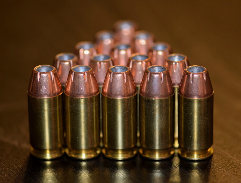 indoors, large group of objects, firearms, rounds, studio shot, group of objects, acp, business, guns, in a row, hollowpoints, table, chl, gold colored