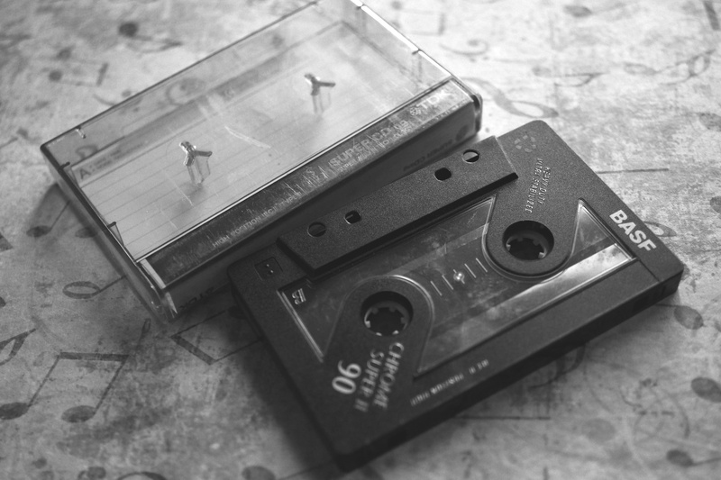 wood - material, focus on foreground, Analog, old-fashioned, handgun, music cassette, weapon, table, magnetband, 2K, still life, indoors, single object
