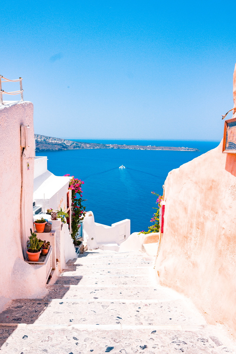 building, beach, built structure, copy space, no people, steps, flora, jar, coast, sunlight, oia, beauty in nature, blue, horizon over water, sea, scenics - nature