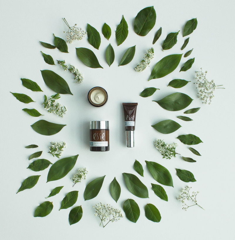 symbol, grass, esse, skincare, arrangement, vase, potted plant, vegetation, container, large group of objects, jar, wall, recycling symbol, still life