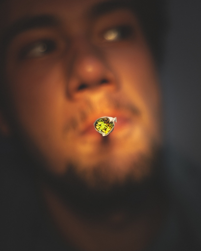 human face, looking at camera, mariuana, thc, adult, body part, young adult, finger, holding, human, green, cbd, joint, healthcare and medicine, grinder
