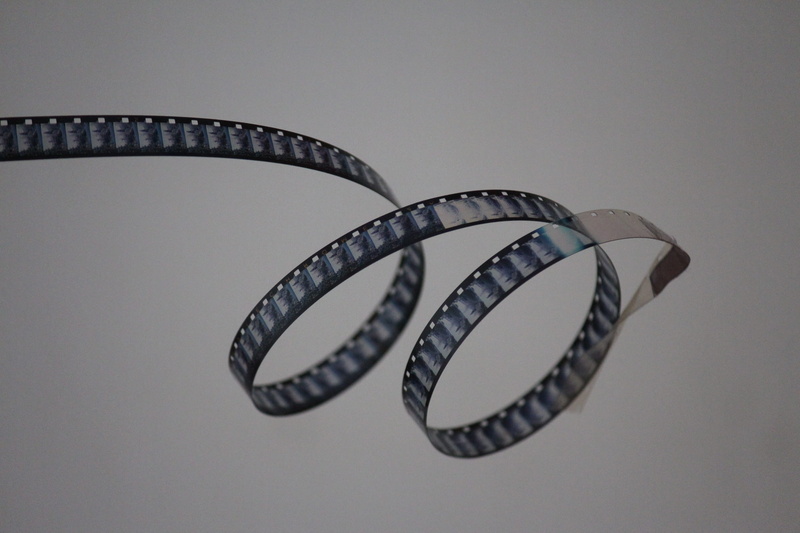 close-up, indoors, creativity, metal, camera, gray background, communication, camera film, photography, spiral, rolling, arts culture and entertainment