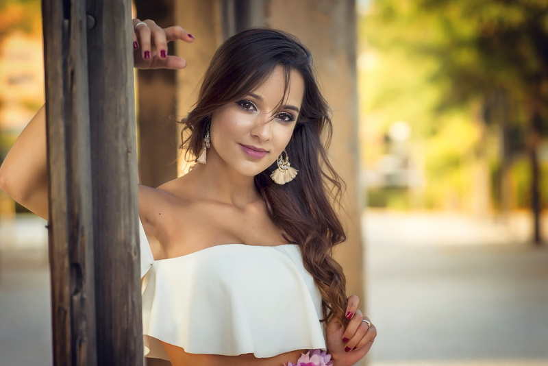 Lucia, looking at viewer, bare shoulders, long hair, model, mouth, portrait, brunette, park, blouse, face, depth of field, strapless dress, 1080P, wavy hair