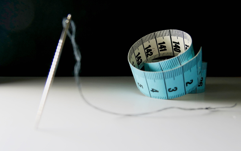 focus on foreground, text, studio shot, indoors, patch, sewing needle, creativity, sewing kits, thread, weight, human representation, fashion, measure
