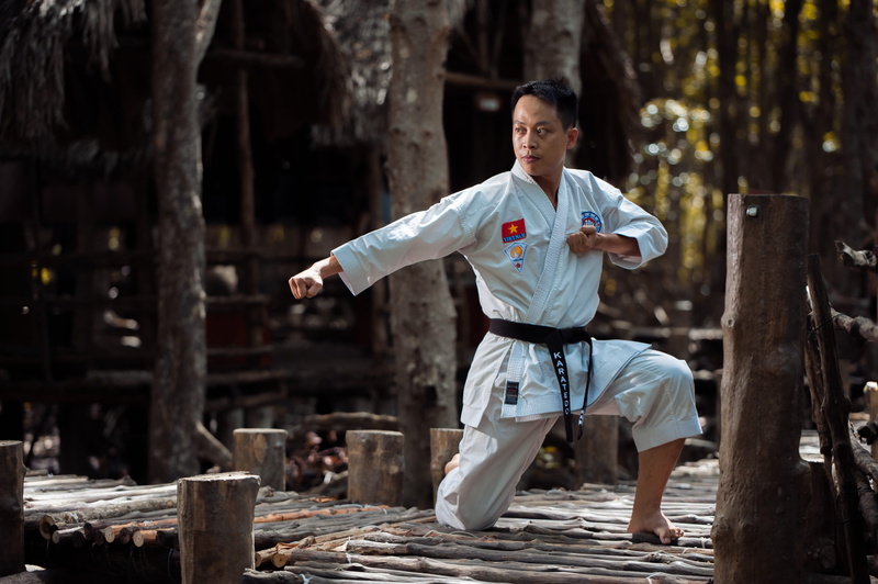 human arm, one person, real people, casual clothing, training, young men, day, martial arts, apparel, bridge, kicking, lumber, karate, front view, wooden
