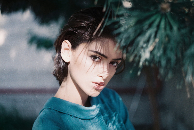 looking at camera, dark hair, girls, portrait, one person, looking at viewer, women, hairstyle, day, women outdoors, lifestyles, brunette, slicked back hair