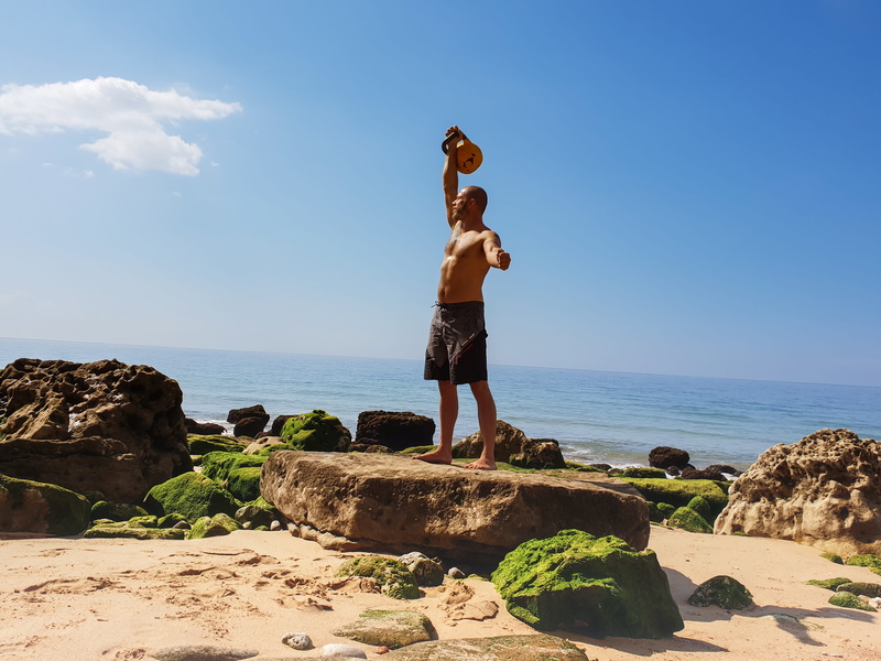 water, sea, arms raised, beauty in nature, nature, full length, kettlebell training, sky, one person, human arm, day, kettle bell, lifestyles, outdoors