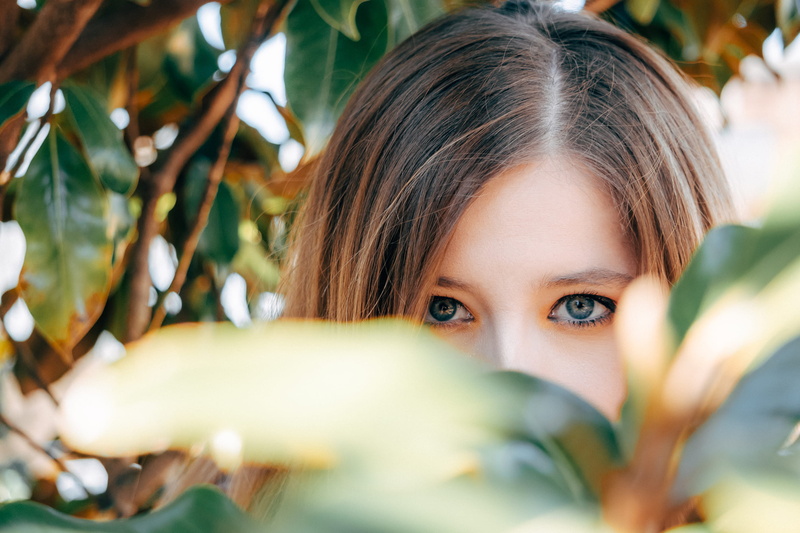 clothing, girl, front view, selective focus, brown hair, hairstyle, unique, lip, day, beautiful woman, finger, leaf, headshot, head, looking at camera