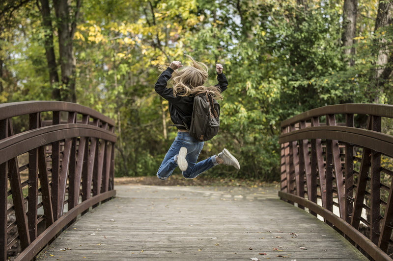 outdoors, males, plant, offspring, tree, day, jumping, railing, childhood, child, shot, children only, fun, schoolbag, happy, running, men, brown, motion