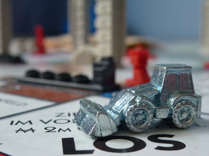 monopoly city, table, technology, game stone, communication, miniature, still life, excavators, close-up, selective focus, text, indoors, bulldozer, board