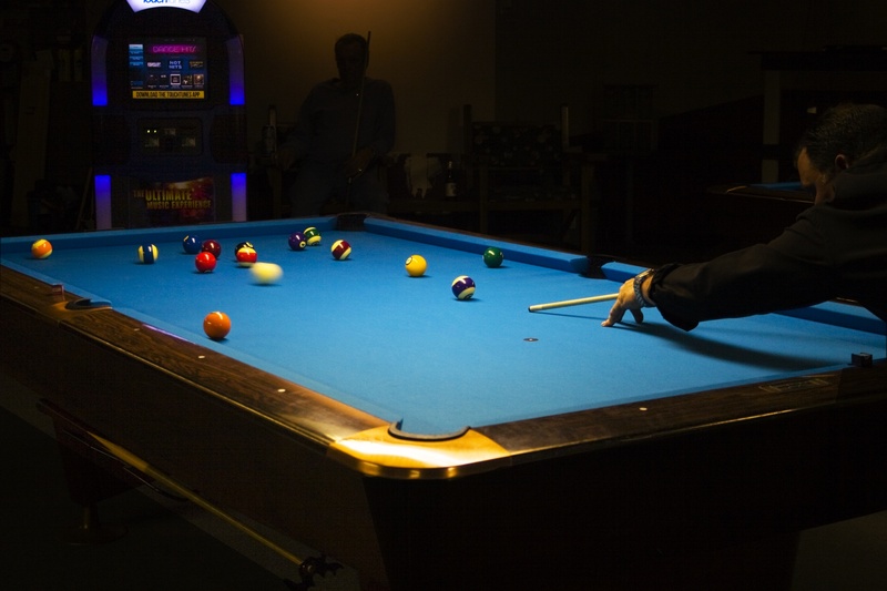 pool hall, men, hobby, one person, dark, billiards, pool - cue sport, nightlife, playing, relaxation, table, real people, indoors, competition, ball, leisure games